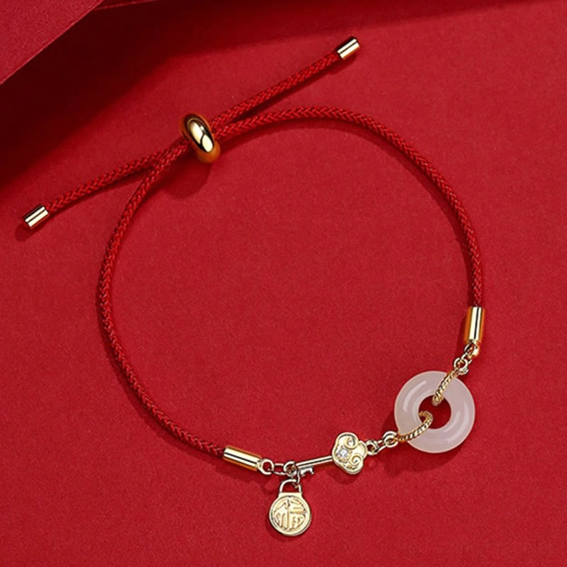 Adjustable red string luck bracelet with Fu pendant and sliding knot closure on red satin