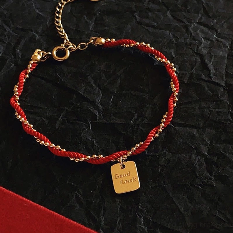 Front top down view red rope bracelet with Good Luck charm and adjustable gold chain