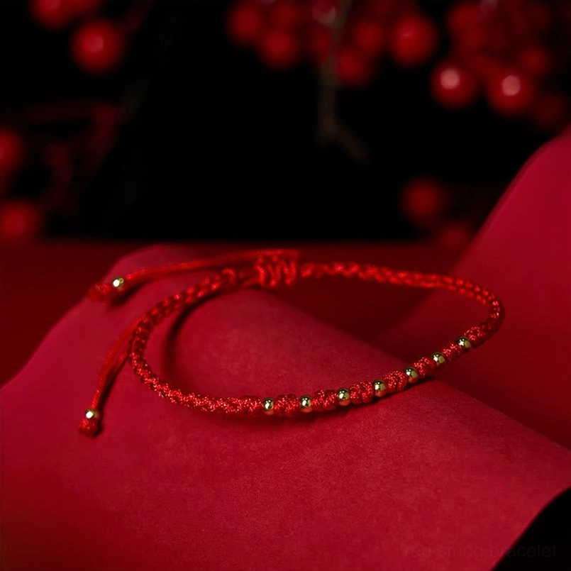 Red woven cord protection bracelet with gold plated beads side angle