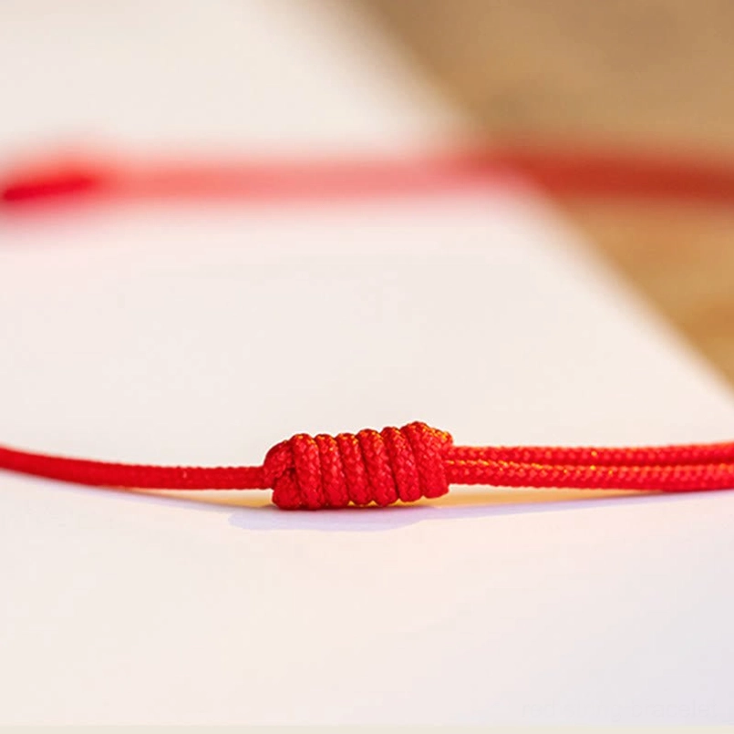 Hand-knotted red woven rope decorative knot close-up on white background
