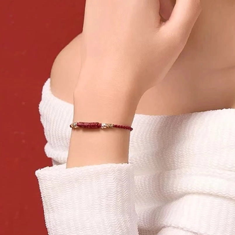 Red string protection bracelet highlighting handcrafted braided cord and cinnabar mantra bead
