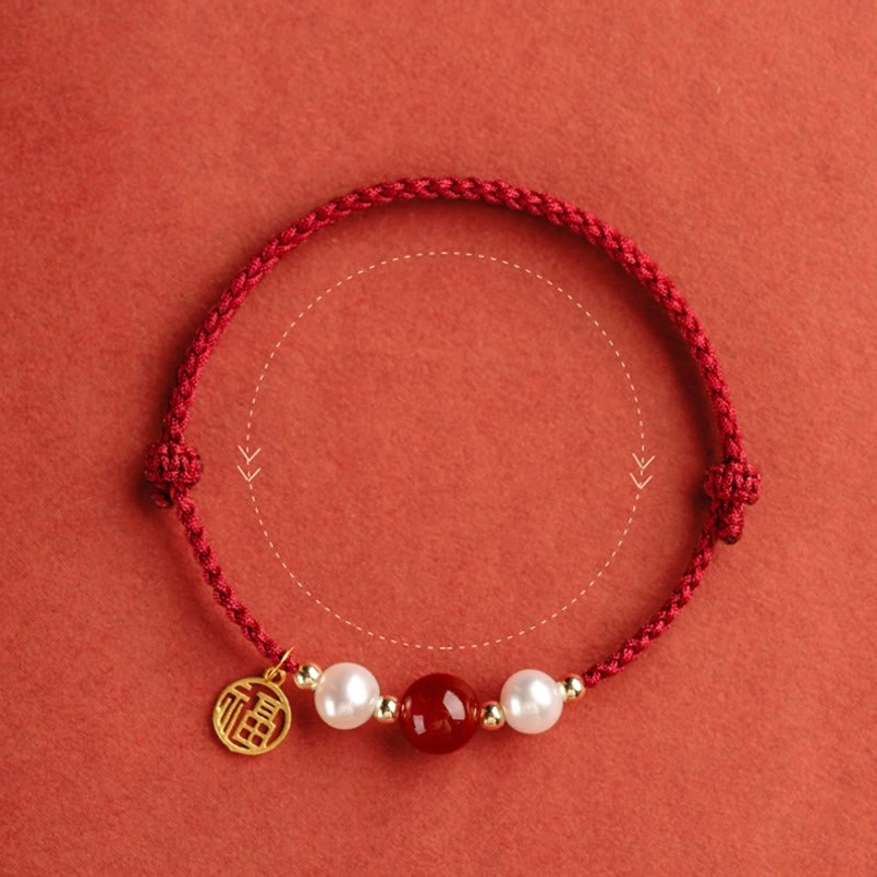 Handmade red string bracelet showing natural bead variations and artisan craftsmanship detail