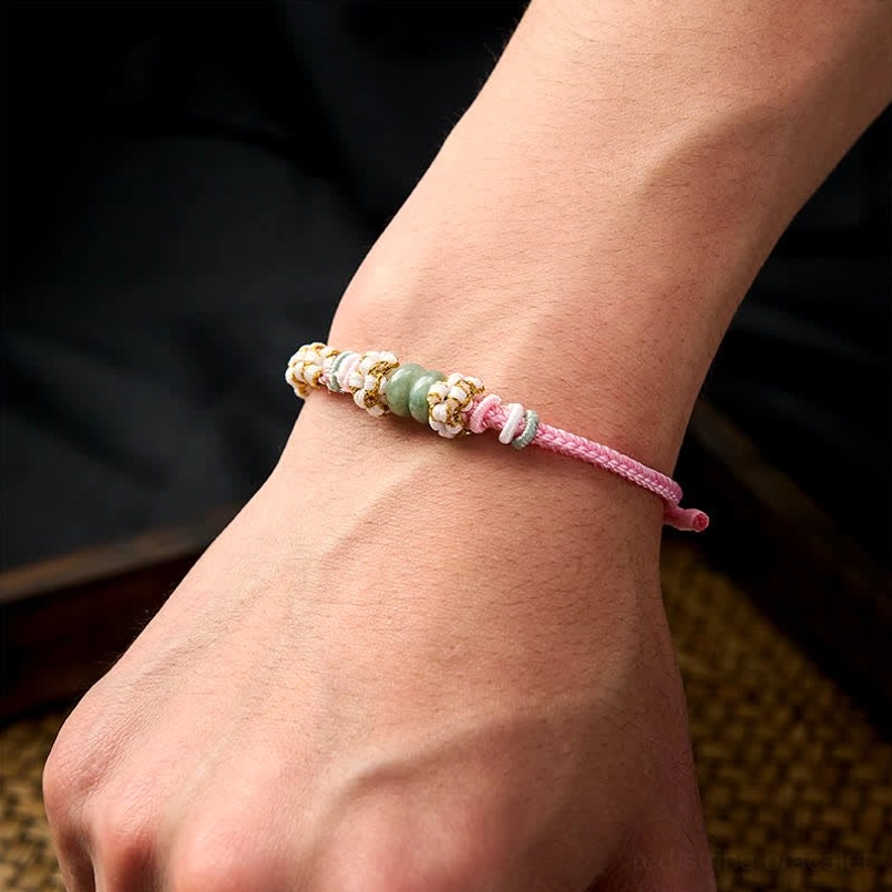 Red Chinese knot luck bracelet detail showing knotting technique and texture