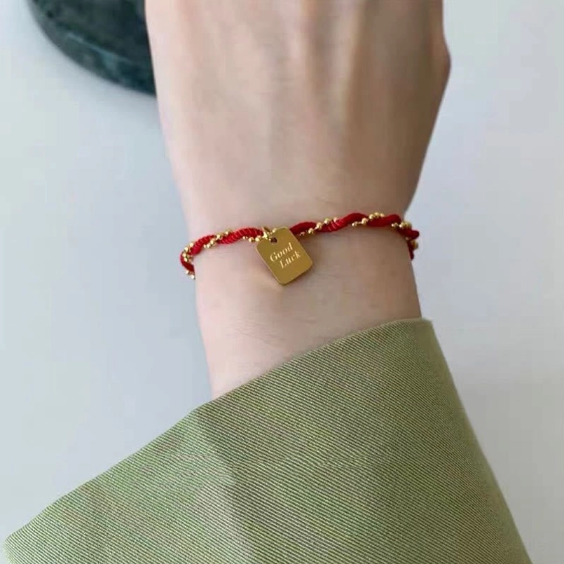 Red string strength bracelet lifestyle shot with daily casual outfit
