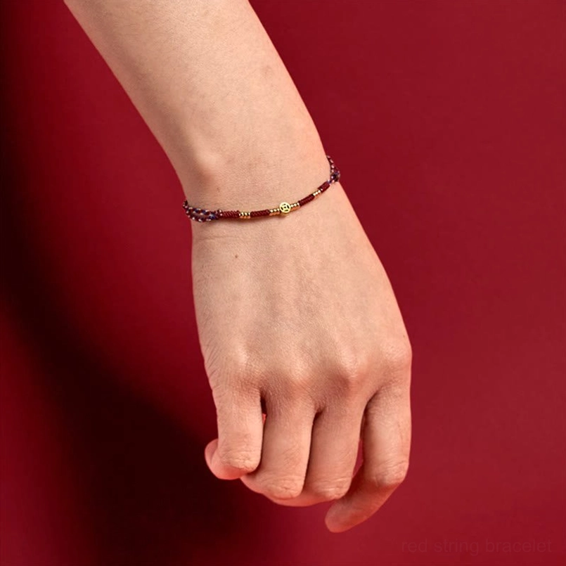 Red string copper coins bracelet worn on wrist, lifestyle product photography showing comfortable fit