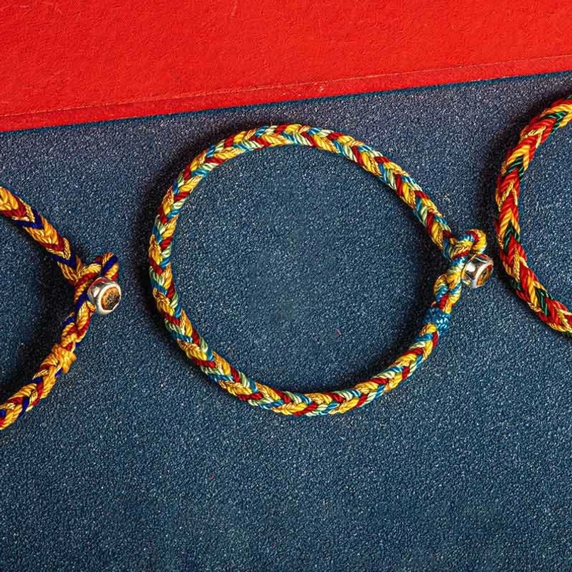 Red string bracelet showing magnetic clasp connection mechanism with detailed view of the sacred knot