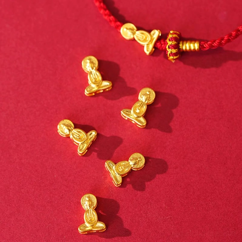 Multiple gold decorative beads and metal accessories attached to red woven rope section