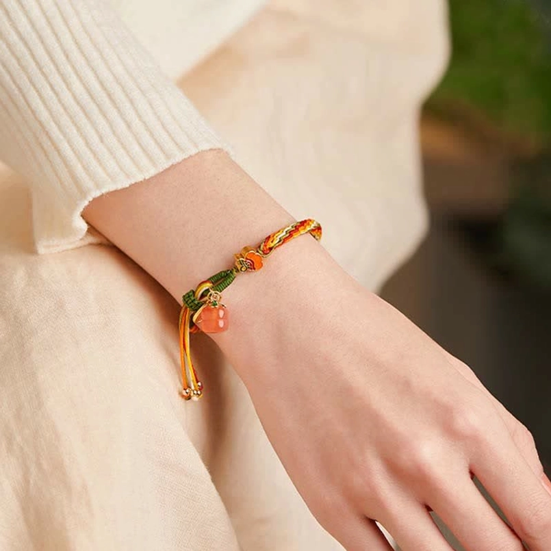 Minimalist red string bracelet with small agate pendant and tassel worn on wrist