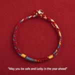 Multicolored red string bracelet with king kong knot and silver buckle flat lay