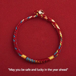 Multicolored red string bracelet with king kong knot and silver buckle flat lay