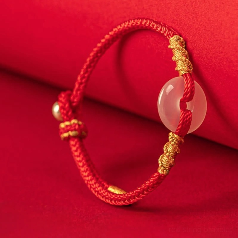 Red string peace buckle bracelet with natural chalcedony stone and golden bead accent, top-down angle