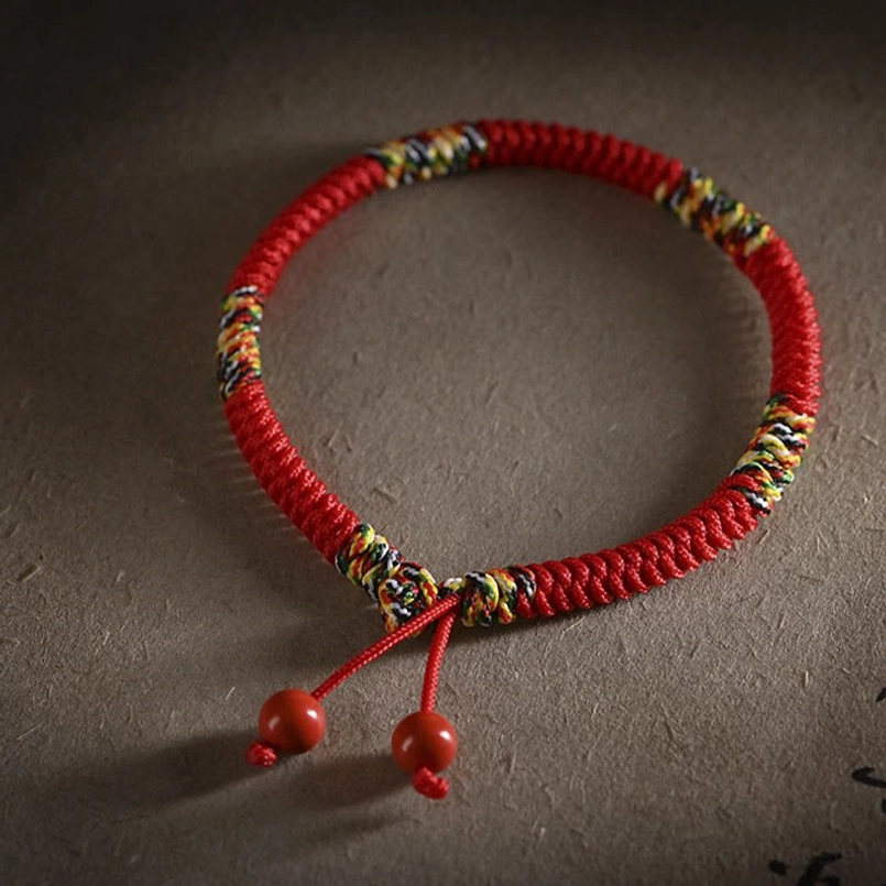 Five colors king kong knot bracelet side view with dual cinnabar pendants dark background