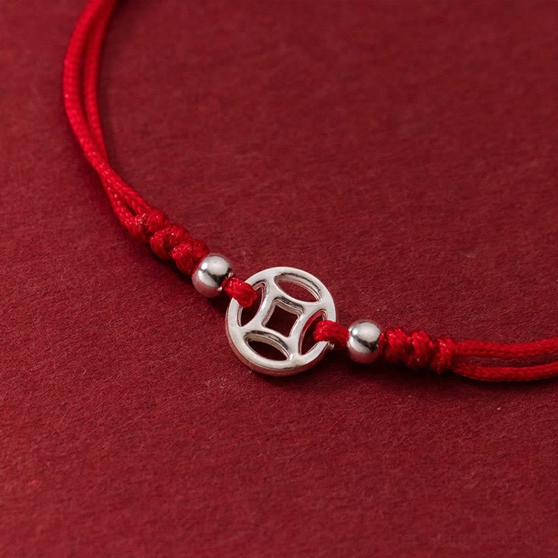 red string bracelet side view showing knotted cord silver coin and sterling silver beads