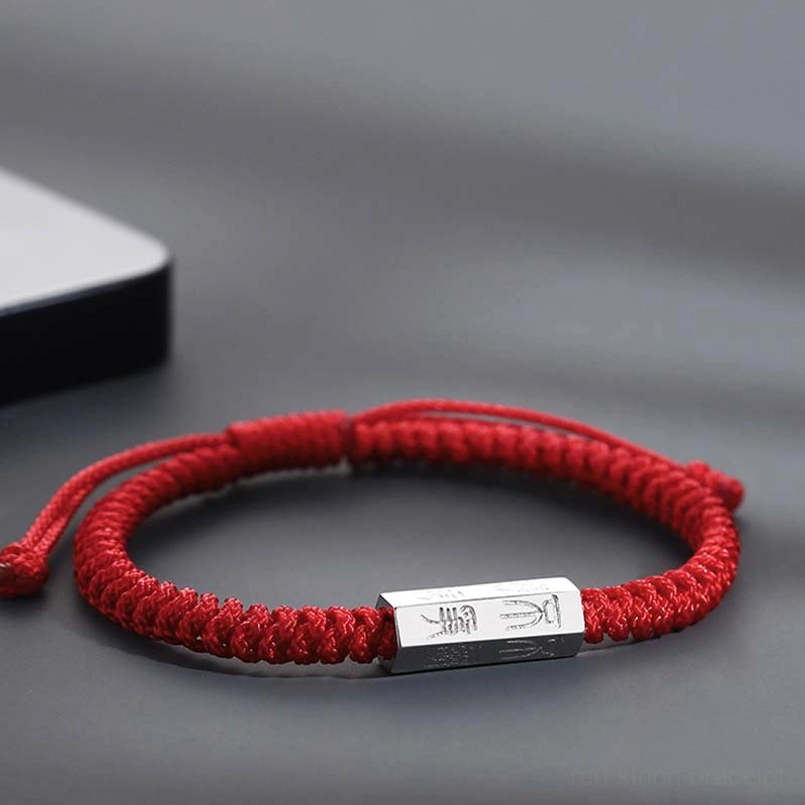 Thick woven red cord red string bracelet with engraved silver bead side view