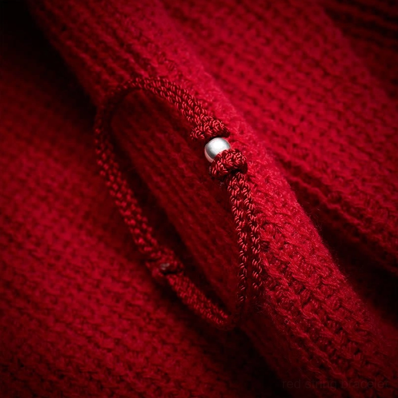 Close up of polished 925 sterling silver bead on braided red string bracelet