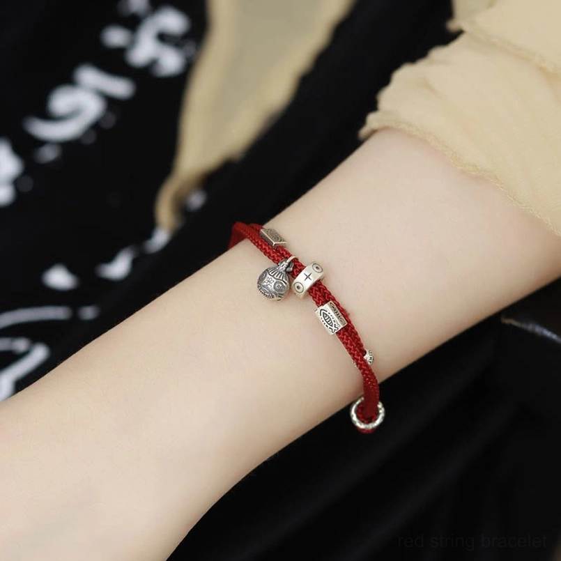 Red string prosperity bracelet with 925 silver beads worn on wrist