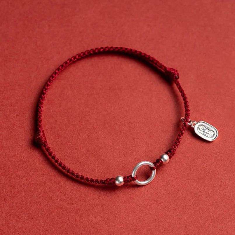 red braided cord sterling silver charm peace buckle bracelet flat lay