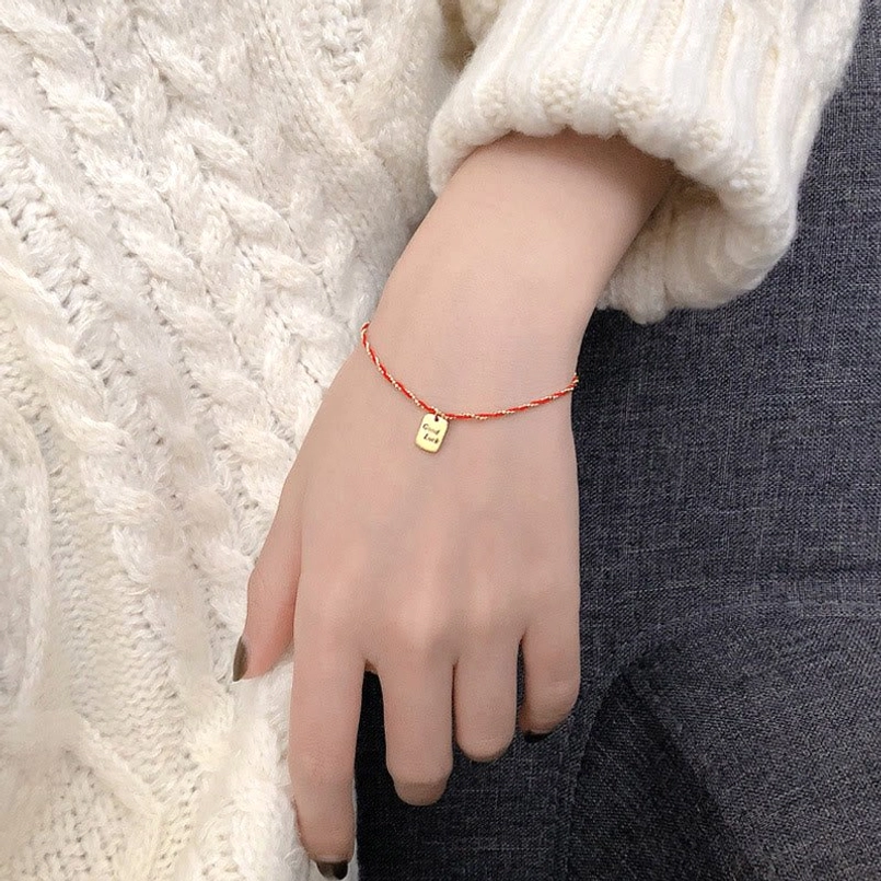 Adjustable red string bracelet size demonstration shot