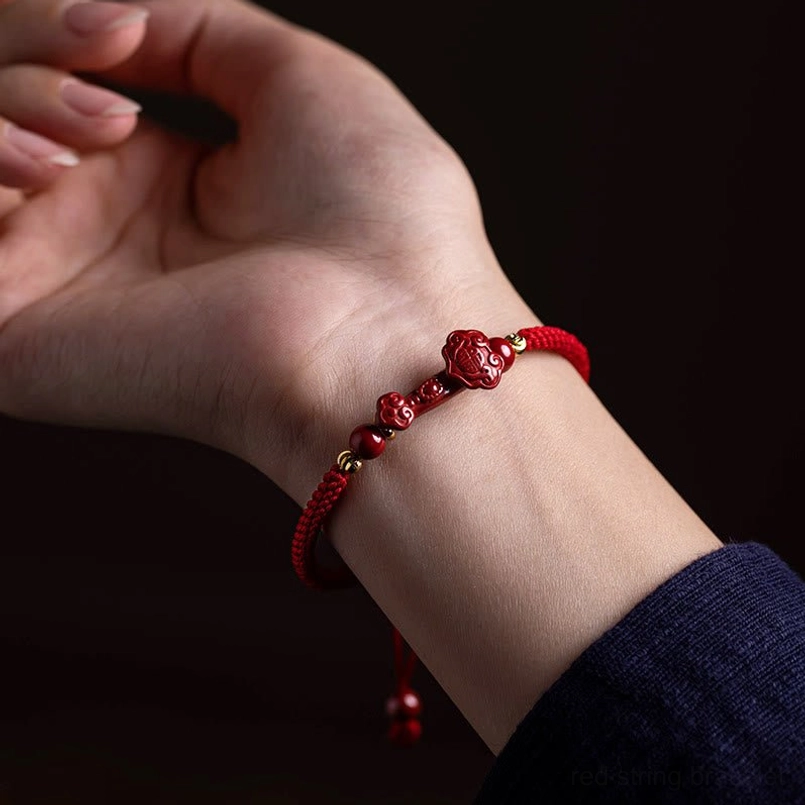 Slim minimalist red string bracelet with small cinnabar beads worn on wrist