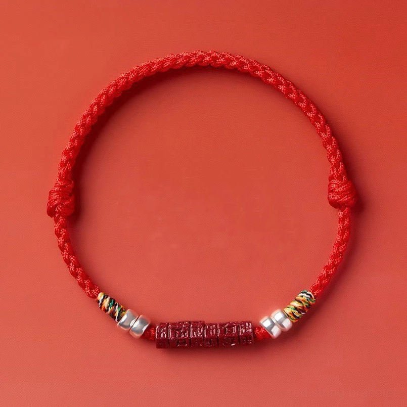 Red string bracelet with sterling silver and cinnabar bead, flat lay photography
