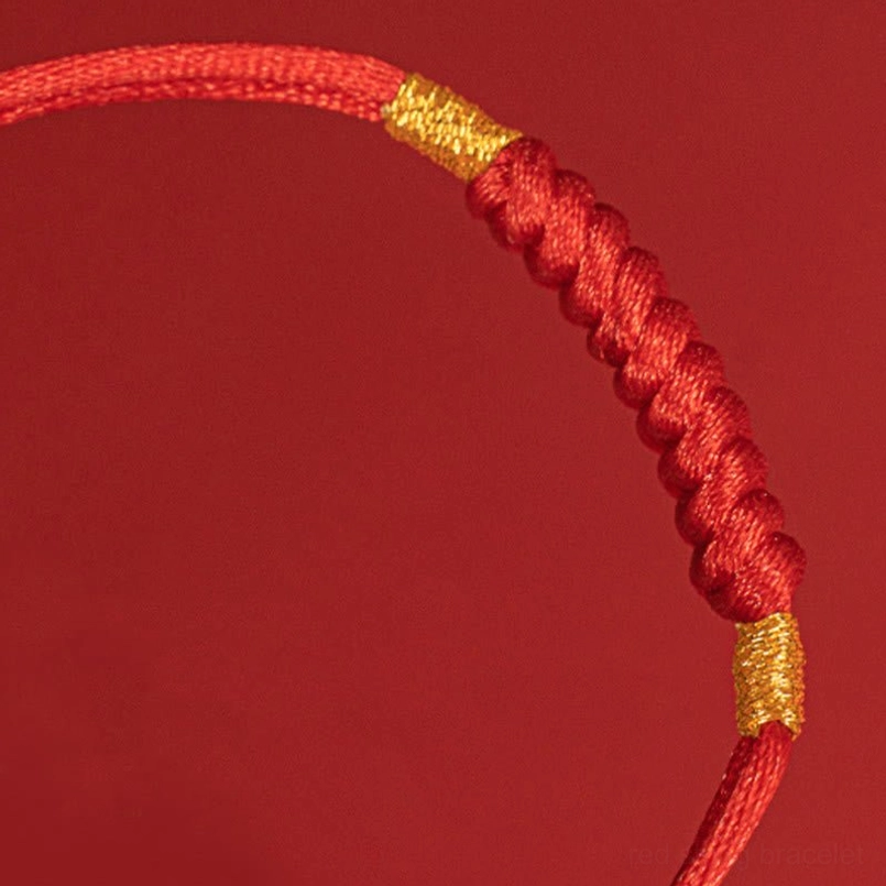 Macro close up of flat lucky knot weave texture on red string bracelet