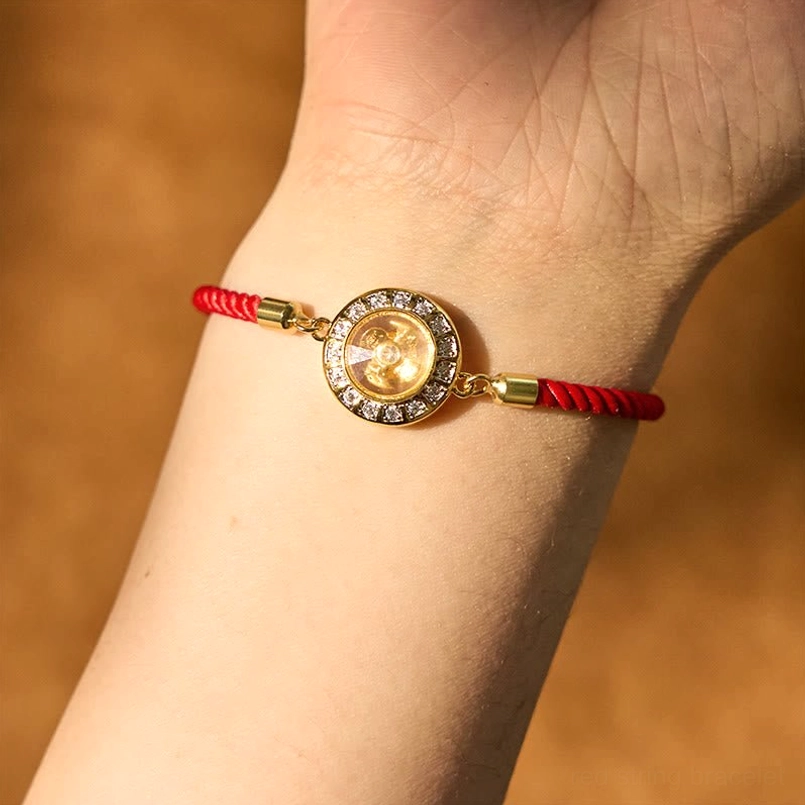 Adjustable red string windmill bracelet worn on wrist, showing comfortable fit