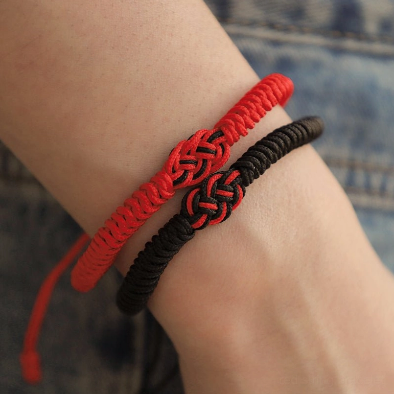 Tibetan red string bracelets worn on two wrists showing adjustable rope fit and comfort