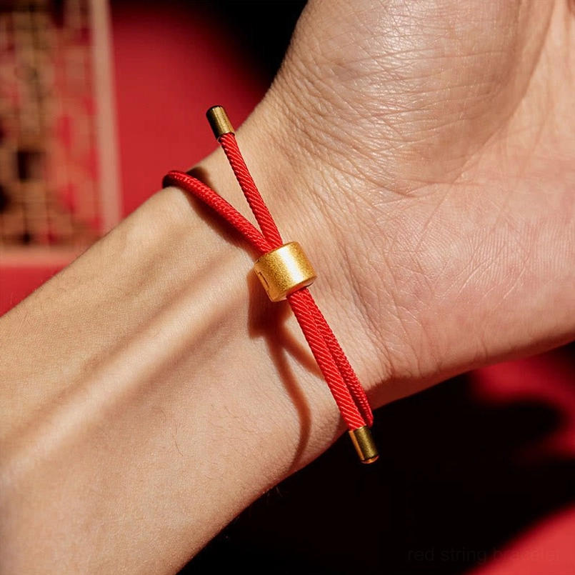 Red string bracelet close up view worn on human wrist dark red background