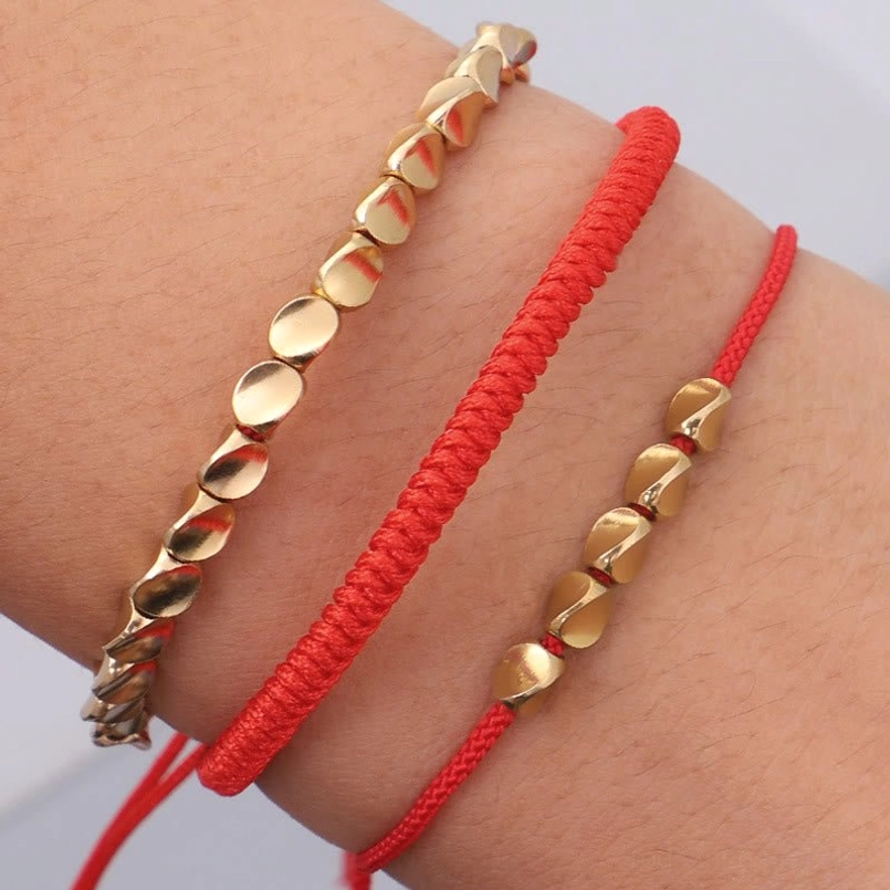 Red string fortune and protection bracelets worn on wrist close-up adjustable cords