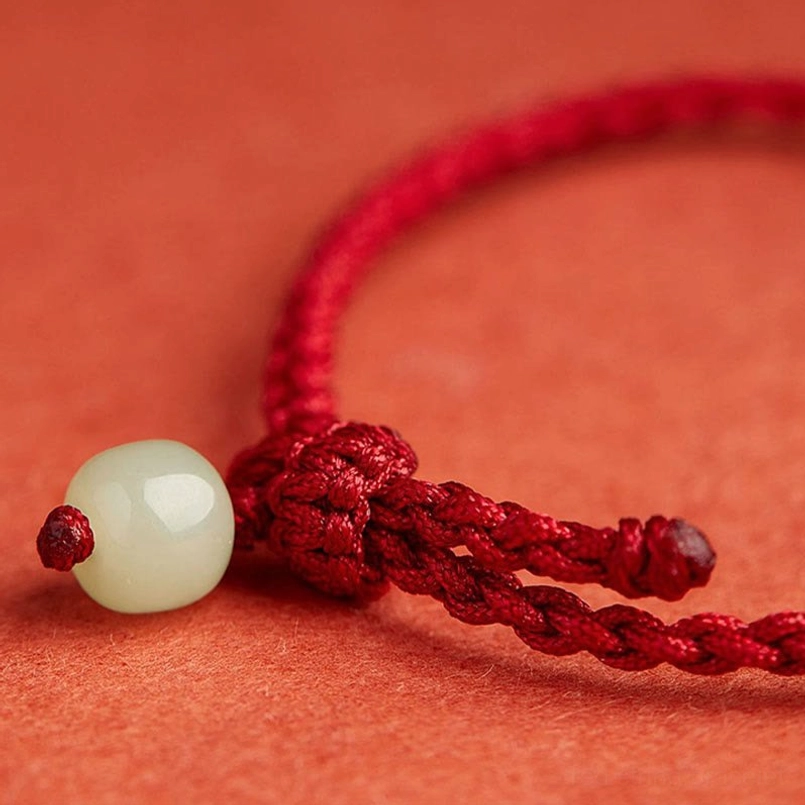 Red string bracelet woven closure knot with jade bead