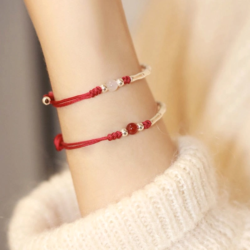 Red string silver bamboo agate bracelet worn on wrist with knit sweater