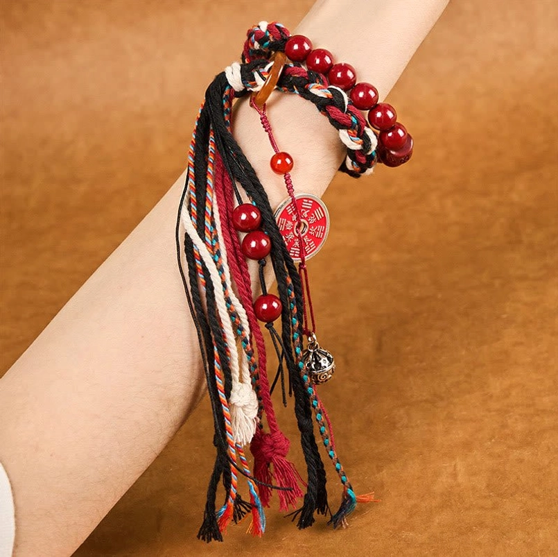Close up side view of cinnabar tassel red string bracelet on wrist