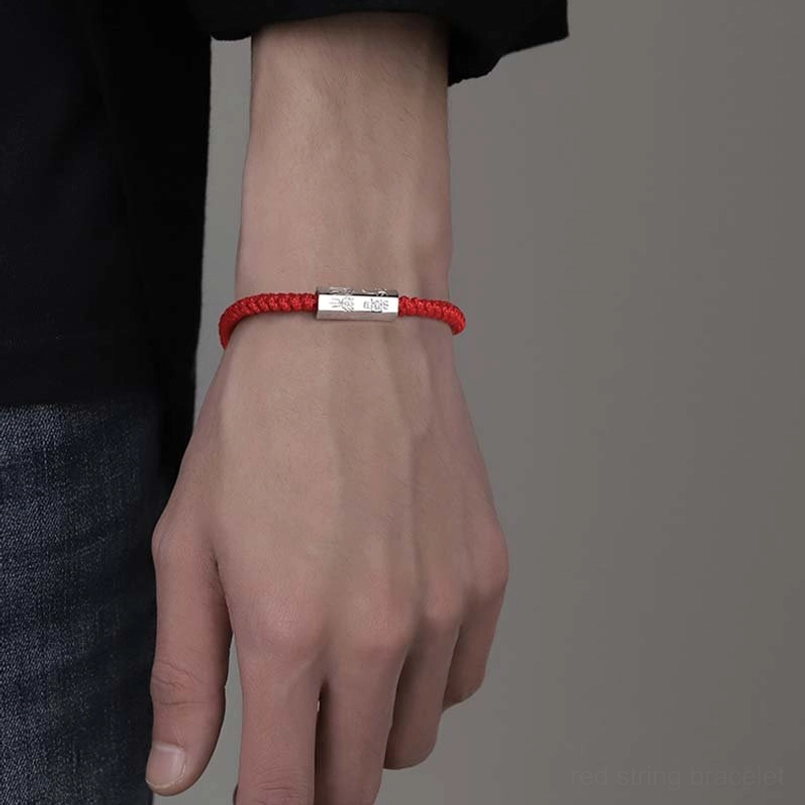 Slim red cord engraved silver charm bracelet front close up on wrist