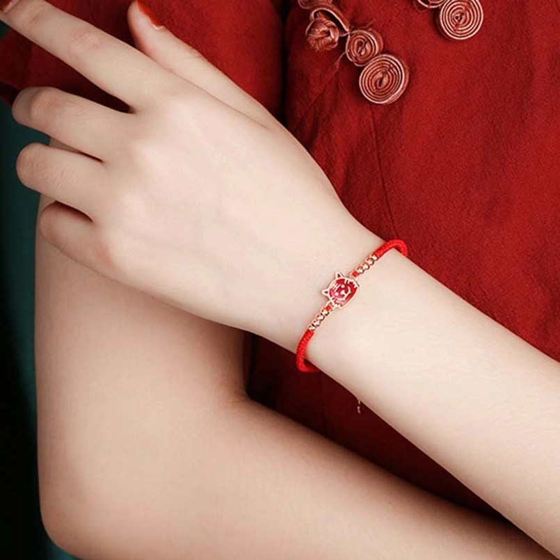 Red string bracelet worn on wrist red cheongsam background adjustable