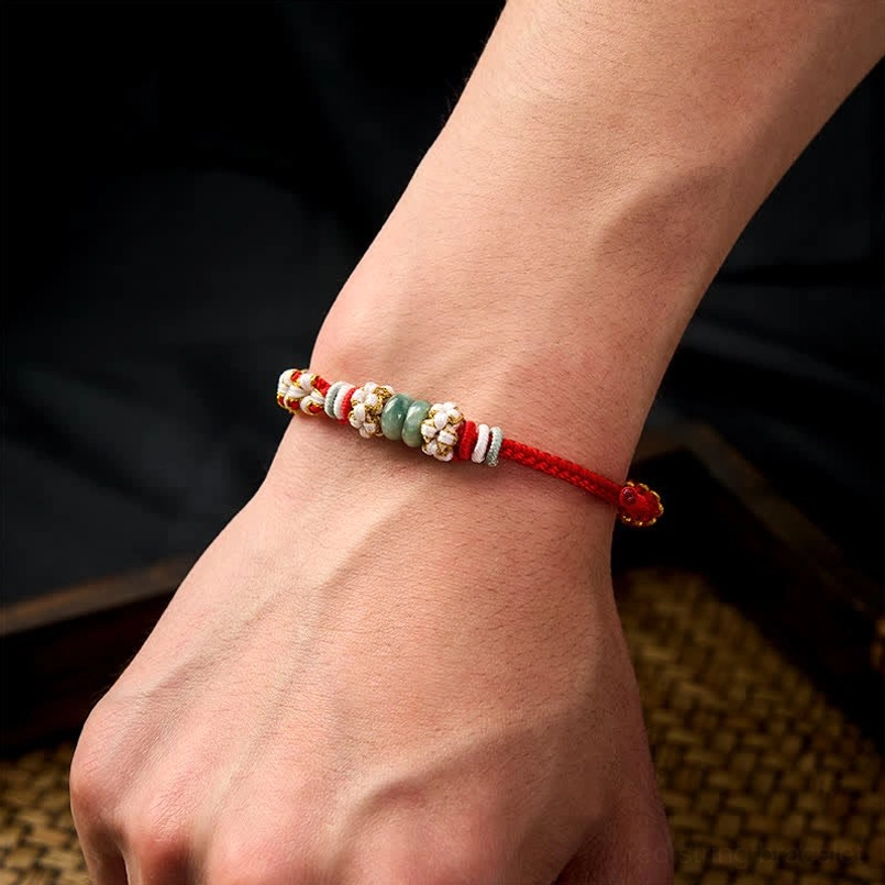 Red Chinese knot bracelet worn on human wrist showing fit and styling