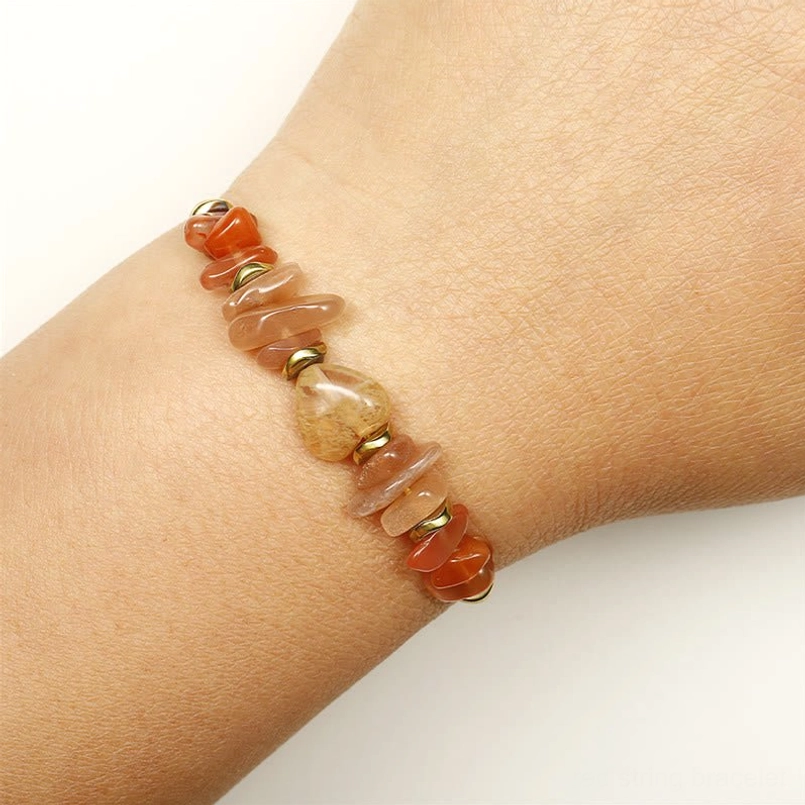 Red string bracelet worn on wrist showing natural gemstone chips and comfortable fit