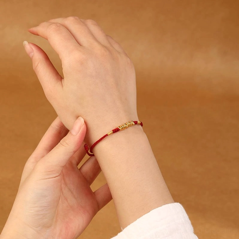 999 gold red string bracelet worn on wrist close-up