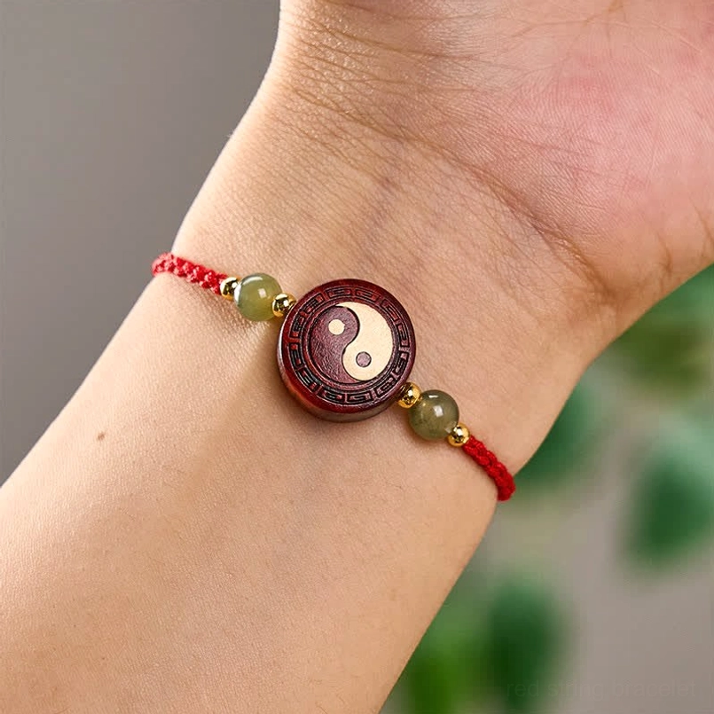 Yin-yang red string bracelet worn on wrist outdoor lifestyle photo
