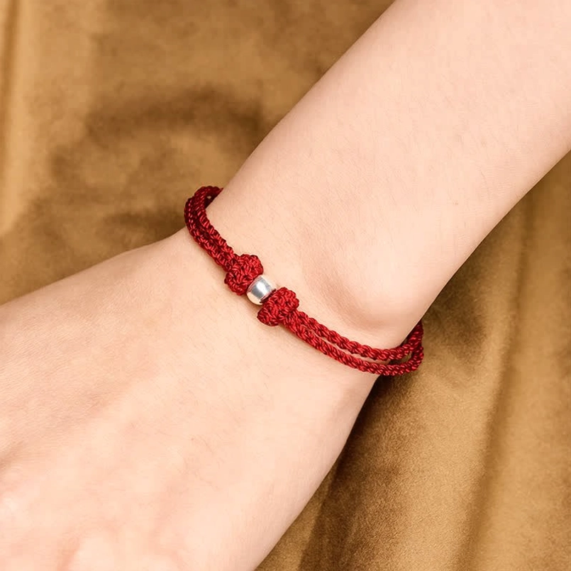 Red string 925 silver bead bracelet worn on human wrist close up fit view