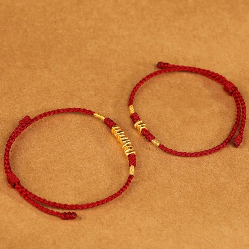 Two 999 gold red string bracelets comparison flat lay