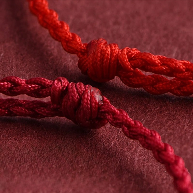 Intricate braided knot detail of red string bracelet showing hand-woven craftsmanship and texture