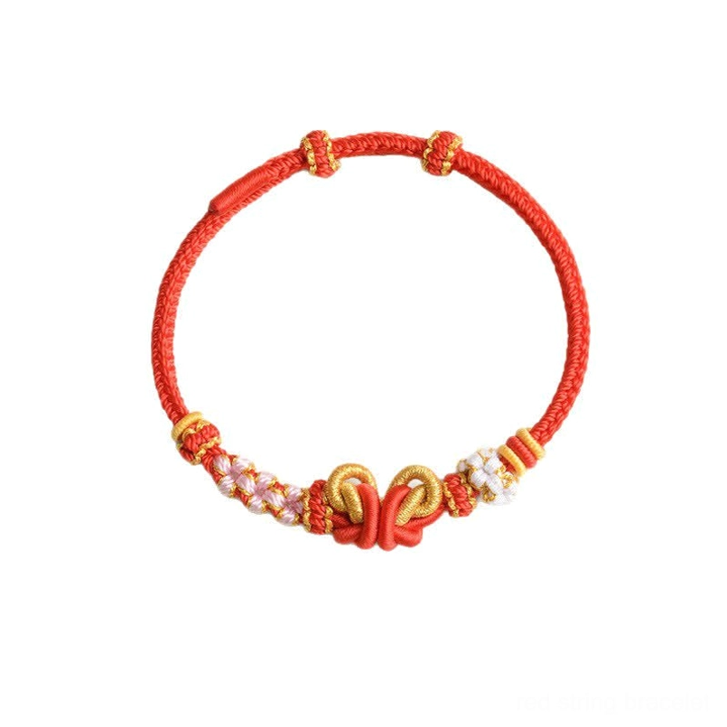 Handmade red braided cord butterfly bracelet with gold double knot and beaded charm overhead view