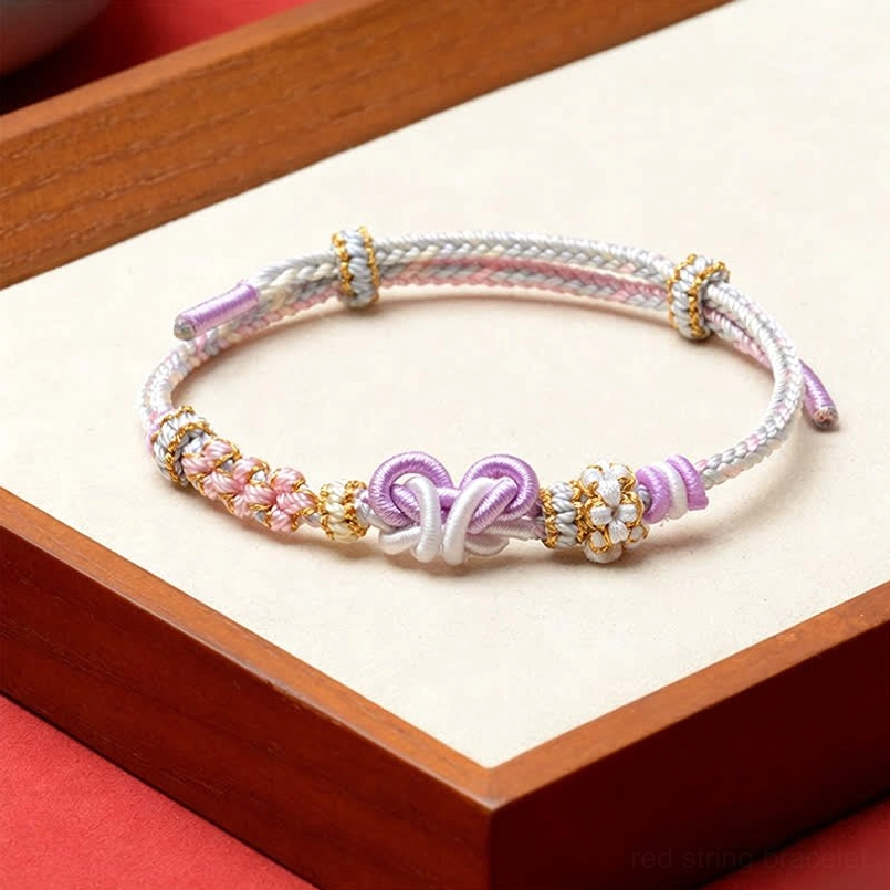 Pastel purple and white woven red string butterfly bracelet with purple double knot detail