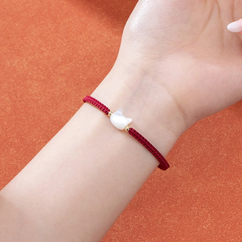 Faceless cat red string bracelet worn on wrist real wearing scenario