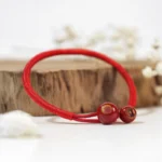 Red string ceramic bracelet front view with wooden decor and dried flowers - feng shui protection bracelet