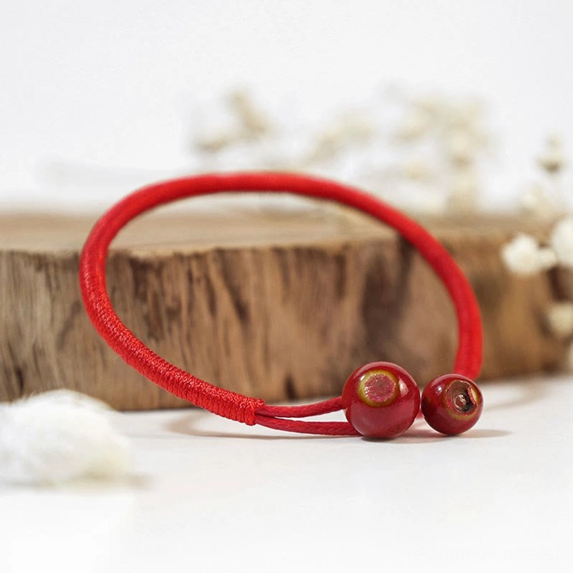 Red string ceramic bracelet front view with wooden decor and dried flowers - feng shui protection bracelet