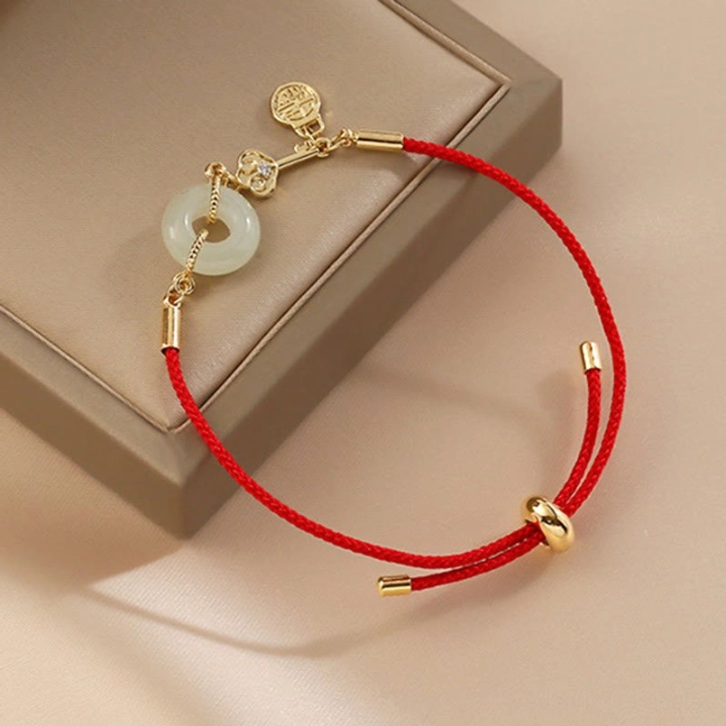 Red string charm bracelet with jade peace buckle Fu character charm and gold tube accents