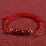 Red braided cinnabar bracelet front flat view with 3 cinnabar beads