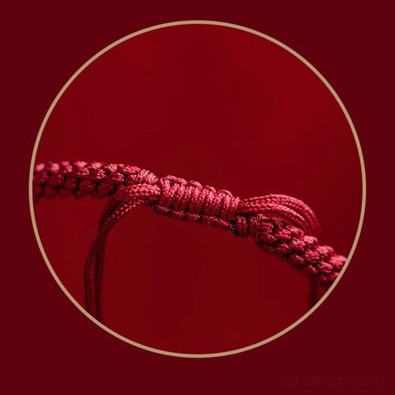 Tibetan red string protection bracelet with carved cinnabar mantra bead close-up