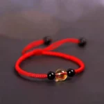 Red string bracelet with citrine and black obsidian beads three quarter side view